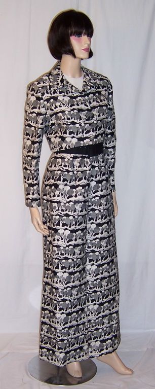 This is a 1960's vintage bold and graphic black and white printed evening gown with a white bodice and matching printed jacket. The print is reminiscent of some African terrain. The gown is long and straight with a slit up the front of the gown, a