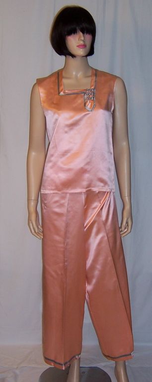 Offered for sale is this buttery soft, three-piece lounging outfit in salmon pink and powder blue silk. The set consists of a sleeveless top and pants in salmon pink trimmed in powder blue and a blue silk jacket trimmed in salmon pink silk with frog