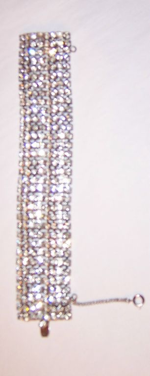 This is a stunning clear rhinestone bracelet with safety chain attached, designed by Weiss. The bracelet is signed and is in excellent condition.