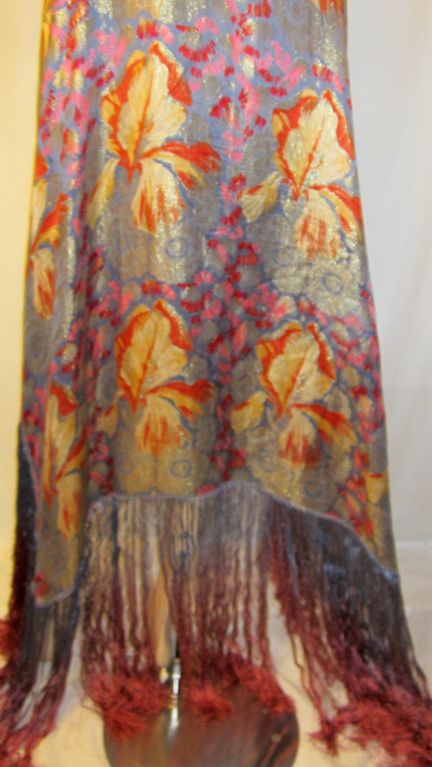 This is a stunning French Art Deco gold lame shawl on a cornflower blue background depicting stylized iris floral designs with wonderful silk fringe in ombre colored treatment<br />
ranging from blue, to lavender, to rose. The shawl measures
