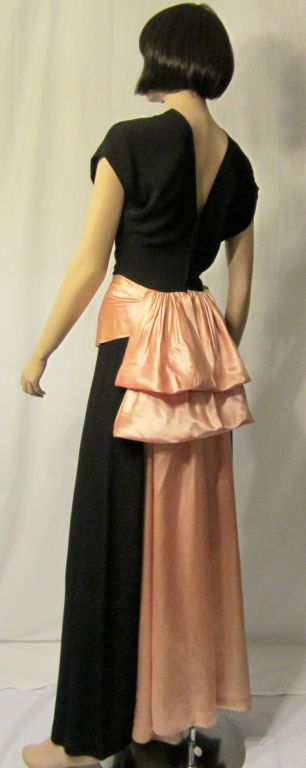 This is one of my most favorite, late 1930's vintage evening gowns because of its striking color combination and its dramatic silhouette. The black crepe gracefully follows the contour of the body while the wide pink satin cummerbund accentuates the