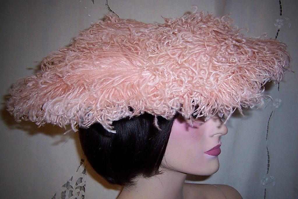 This is a wonderful, 1950's vintage, saucer-shaped hat covered in pink ostrich feathers and designed by a very talented milliner. The interior is lined in pink satin and is masterfully constructed with flat strips of metal covered in fabric and
