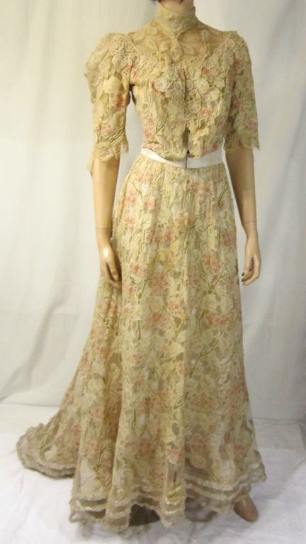 This is a delicately beautiful Victorian three-piece ensemble consisting of a slip, bodice, and skirt with a train. The bodice is boned and fitted and has a series of hooks and eyes for closure as does the skirt. Pink and green appliques cover the