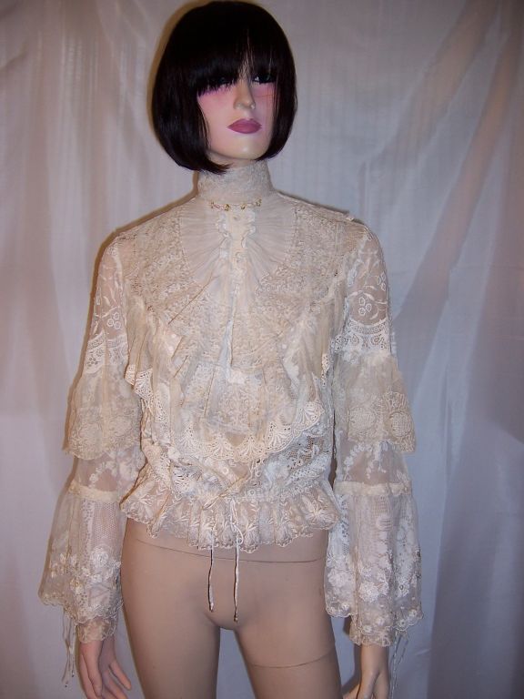This is an exceptionally beautiful blouse, of the 1970's vintage, made of finely made mixed lace materials in the Victorian style. The blouse is masterfully crafted with a mandarin collar, ruffled bodice of two layers, draw-stringed waist, full and