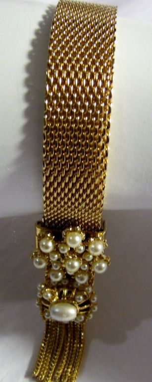 This is a gorgeous Victorian styled gold mesh slide bracelet, unmarked but probably gold filled. The slide and tassle guard are encrusted with pearls of varying sizes and shapes. The bracelet is in excellent vintage condition and is adjustable to