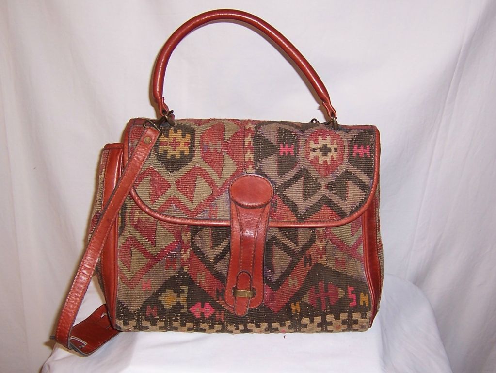 This is a wonderful brown leather bag made from an antique Turkish kilim. The bag is in very good vintage condition with some slight wear to the woolen fabric at either side panel of the bag, which I have photographed. It has a shoulder strap which