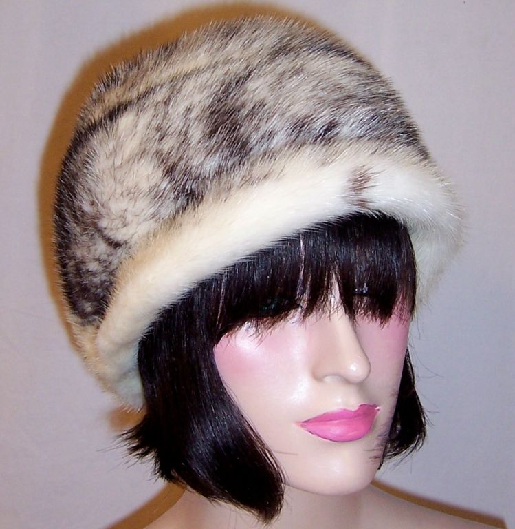 This is a stylish Mr. John Fabulous Furs, New York-Paris, white and black mink hat. Mr. John was one of the foremost American milliners of the 20th century. He was more concerned with a flattering fit and fine construction than he was with fancy
