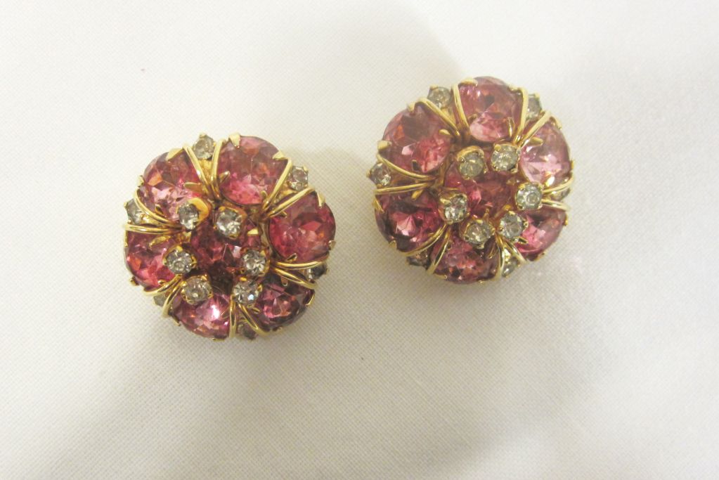 This is a stunning pair of pink and clear rhinestone  clip-on earrings on gold-toned metal created by Hattie Carnegie and stamped on the reverse side, 