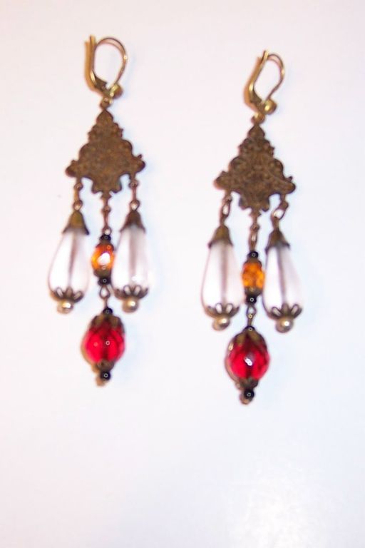 This is an exquisite pair of Czechoslovakian dangle earrings made of intricate brass findings, white pear-shaped, frosted beads, red and amber beads, and tiny multi-colored rhinestones. Each earring measures 1