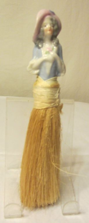 Offered for sale is this very collectible, 1920's porcelain figural hat brush or boudoir brush. These are often referred to as half dolls. This particular one measures approximately 8
