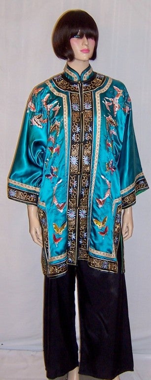 This is a gorgeous deep turquoise Chinese silk jacket lavishly embroidered with a variety of butterflies. This jacket probably dates to the 1960's-1970's and is in excellent vintage condition. It has been trimmed with a black border with embroidery