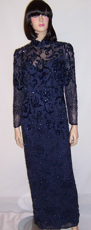 This is a dramatic and stunning midnight blue, beaded and sequined floor length evening gown designed by Oleg Cassini.
Oleg Cassini was most notably famous for being appointed Jacqueline Kennedy's personal and official designer in the 1960's.  This