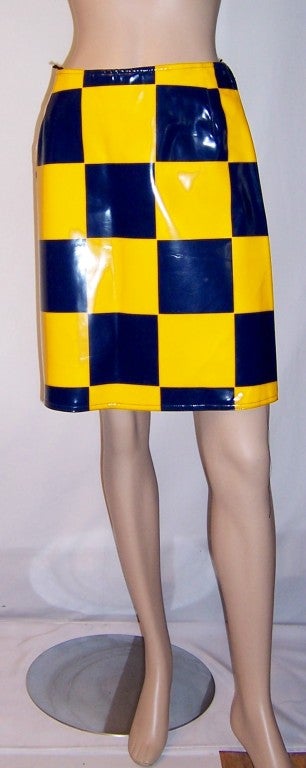 Offered for sale is this rare and collectible, unworn with the tag still attached, Comark patent vinyl navy and yellow checkered skirt. The skirt is marked a Size 9, but would be more equivalent to a modern day Size 6. It is in excellent vintage