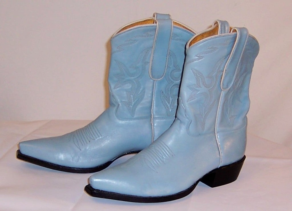 This is a wonderful pair of baby blue leather Caborca cowboy boots trimmed in white piping. Caborca is a privately owned boot company in Mexico known for the quality and craftmanship of their boots.  This pair is marked a Size 8 1/2 B and is in
