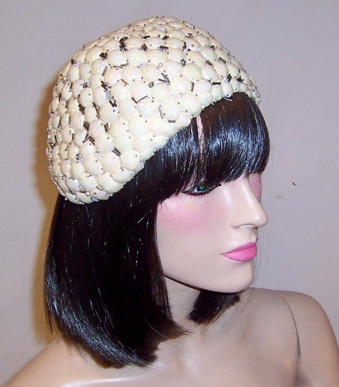 Offered for sale is this rare and unusual 1920's white skull cap made from hundreds of convex pieces, a little bit smaller than a dime, of an early plastic type material, interspersed with glass bugle beads and the occasional pearl. The hat's