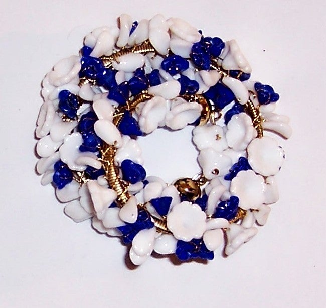 This is an amazingly beautiful, hand-made bracelet on a thin gold-toned, gas pipe chain coil with hundreds of poured glass florets in white and cobalt blue, each individually wired onto the coil.  When stretched out, the bracelet measures