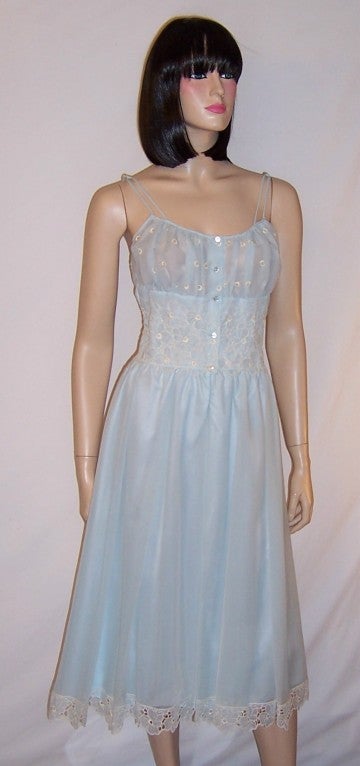 This is a stunning powder blue negligee whose bodice, waist line, and hem line are embellished with white embroidered flowers.  This lovely negligee, which is in excellent vintage condition, had been manufactured for B. Altman and Company Fifth