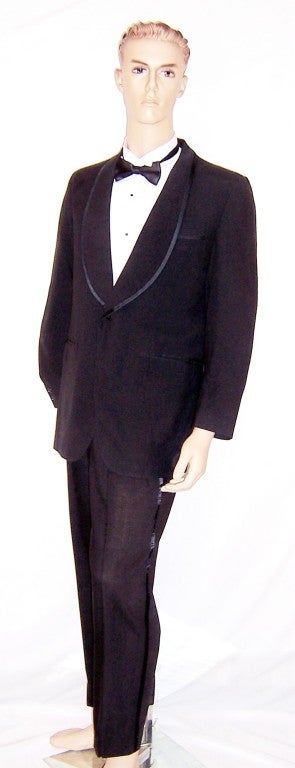 This is a striking and stylish, early 1960's, fine woolen tuxedo, whose lapels and pants are trimmed in satin. The tuxedo is marked a Size 41 Long and is in excellent vintage condition both inside and out. The jacket measures 18