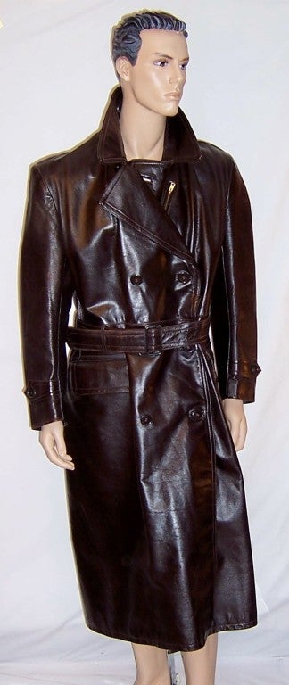 Offered for sale in this incredibly well made, 1940's vintage, men's brown leather, double-breasted, greatcoat which is fully lined and finely detailed. The coat has a zippered pocket in the left chest area and two flap pockets at each hip. The