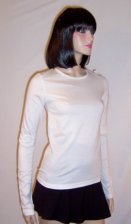 Offered for sale is this stark white, slightly avant-garde top designed by Helmut Lang in 1997.  Lang's style often reflects an urban, modern, and even futuristic perspective. The top is a Size Small and it measures only 30