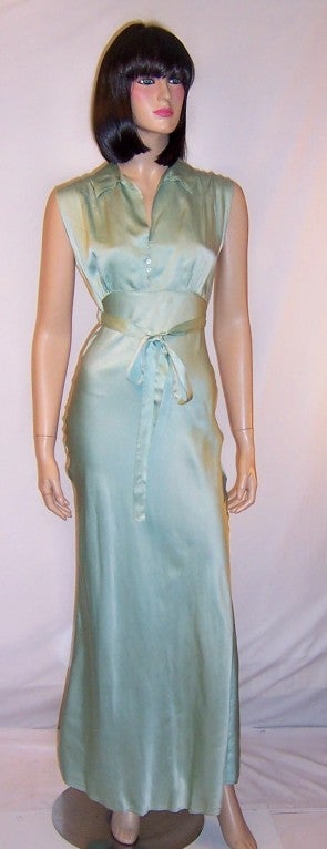 This is a gorgeously simple, pale teal green, bias cut negligee/gown of silk and rayon with a slightly empire waist line, peter pan collar, fitted bodice with six pearl buttons for closure, and a thin, long silk belt that may be tied into a bow