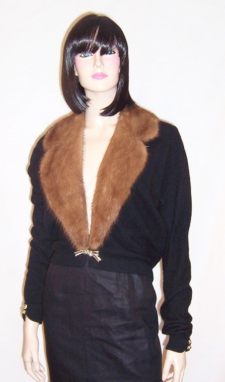 This is an elegant and stunning black evening cardigan with a full mink collar, a rhinestone bow buckle, and rhinestone decorative buttons at each cuff.  The sweater would be comparable to a modern day Size Small and is in excellent vintage
