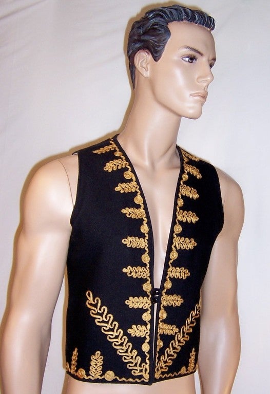 Offered for sale is this fantastic men's, 1960's vintage, black woolen vest with a two button closure and embellished both front and back with gold cord trim/passementerie. It was designed by Marshall Lester for Scott Lester LTD. England. It is very