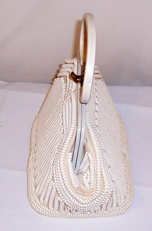 This is a charming and unusual late 1940's-early 50's, white plastic coil summertime handbag. These handbags were often referred to as telephone wire handbags and were usually made in two or more colors. This particular one is boxy in shape and