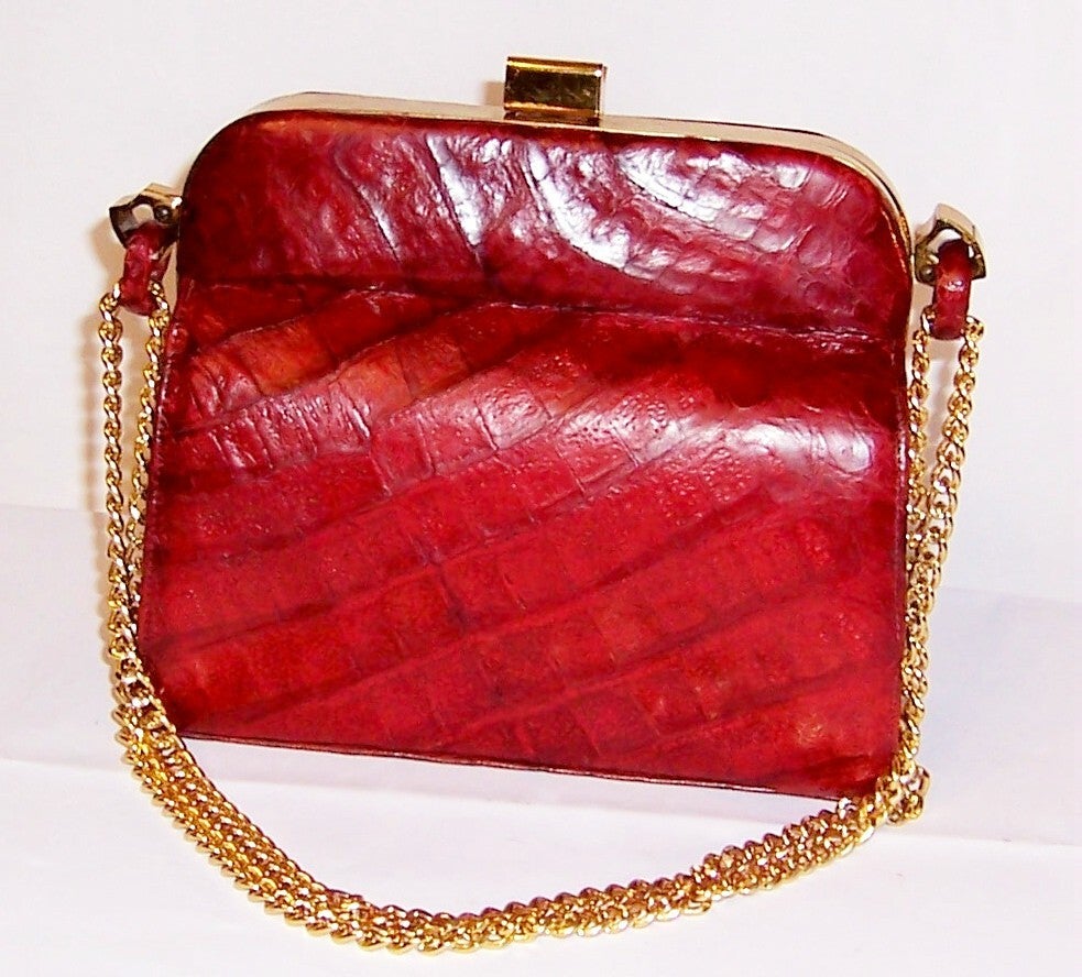 Offered for sale is this handsome, 1940's vintage, red alligator handbag with elegant and chic gold-toned frame and hardware in excellent vintage condition. The bag itself has no label in its interior. However, there is a small circle at the base of