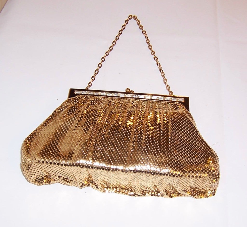 This is a wonderful 1950's vintage, Whiting & Davis gold mesh evening bag whose frame is embellished with a row of clear baguette rhinestones. The bag is stamped Whiting & Davis in the metal frame's interior and it is also tagged with a fabric