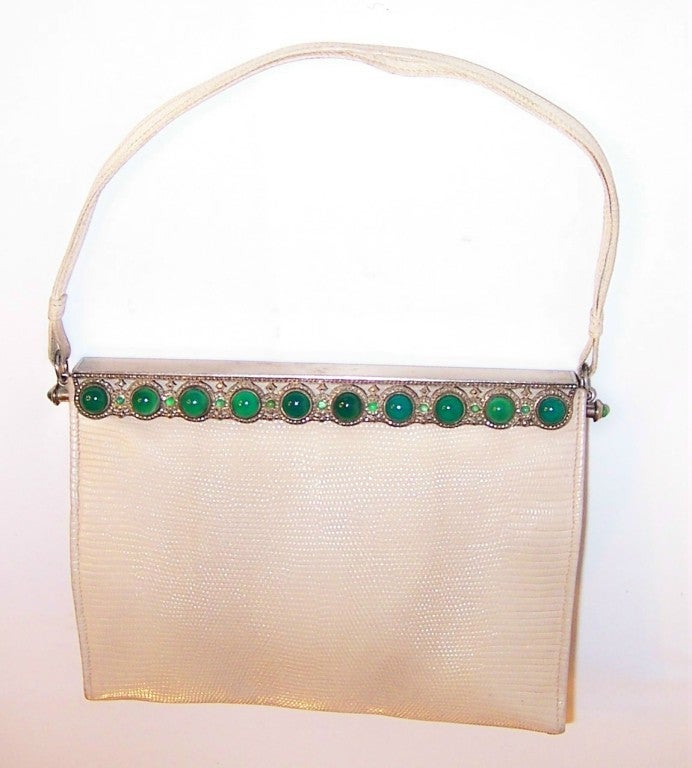 This is a handsome, wintry white lizard evening bag with an elaborately decorated silver-toned frame of brilliant green chrysoprase stones surrounded by marcasites.  Chrysoprase is a vivid green cryptocystalline quartz and a variety of chalcedony.