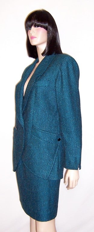 This is a beautifully designed and constructed turquoise and charcoal gray herringbone tweed suit designed for YST by Reuven and made in Italy.  The herringbone tweed jacket is double breasted with diagnonal pockets and interesting details at each