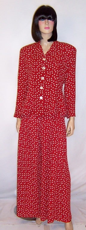 This is a festive and fanciful red and white polka-dotted pant suit designed by none other than Betsey Johnson.  The jacket is slightly fitted, hip length, has a belted back, and five pearlized buttons for closure down the front.  The palazzo pants