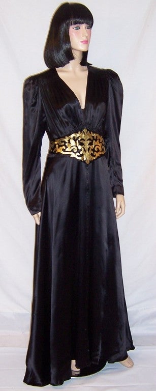 This is a dramatically striking and glamorous, 1940's vintage, floor length, black charmeuse gown with a wide cummerbund-type of belt which has been embellished with gold leather appliqued cut-out designs.  This typically 1940's silhouette has a