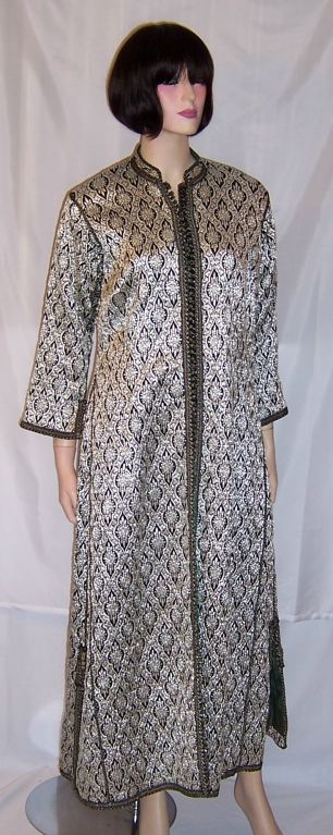 This is a striking and handsome, 1920's vintage, black and silver metallic/lame Indian robe. It has distinctive Indian motif patterns repeated throughout the design. There are over one hundred tiny round, hand-made buttons embellishing the robe from