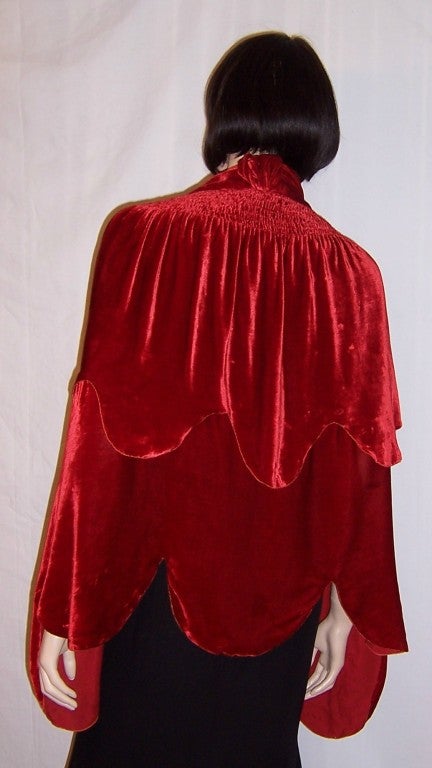 Offered for sale is this luxurious and beautifully designed, 1920's vintage, crimson silk velvet cape.  Its anonymous deigner would have been considered a master of the ruching and draping techniques.  The cape is in extremely good vintage condition