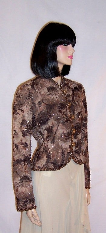 Offered for sale is this handsome beaded evening jacket in hues of deep umber, creamy taupe, and medium brown depicting large floral patterns, designed by Emanuel Ungaro for his Parallele, or pret-a-porter line.  The evening jacket has long sleeves,