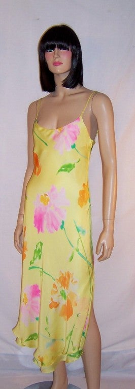 This is a stunning and sleek yellow floral printed silk, slip gown with a scooped-out neckline, spaghetti straps, a side zipper for closure, and a slit up either side of the gown.  The gown measures 14