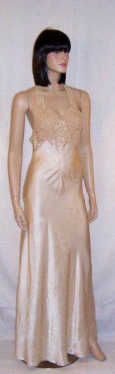 This is a gorgeous, 1930's vintage, hand-made, buttery soft silk champagne-colored negligee with a halter neckline. The fitted bodice and neck straps are made of Alencon embroidered lace. Directly below the bodice are some pintucks and slight