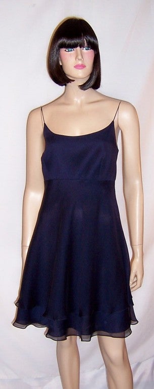 This is an elegant and flirty midnight navy chiffon cocktail dress with a scooped neckline, spaghetti straps, and a back zipper for closure. The label is present and in tact and reads Kay Unger Evening.  The dress is marked a Size 6 and measures 18