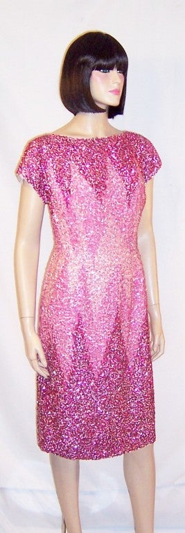 This is a striking, 1960's vintage, orchid-colored, beaded and sequined cocktail dress executed in an exaggerated ombre treatment with each shade of orchid terminating in a series of points.  The dress has short sleeves and a back zipper for