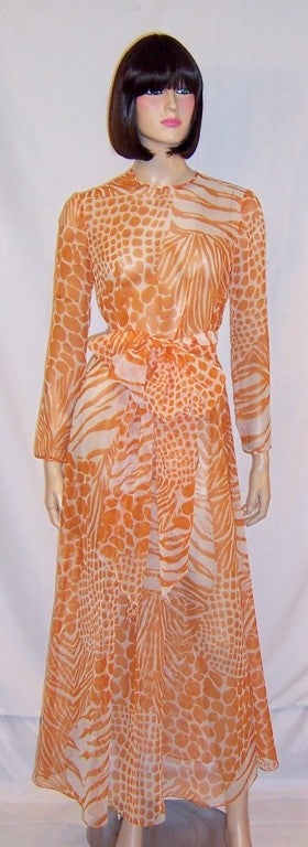 This is a simple and crisp summertime gown of orange and white synthetic chiffon in an abstract animal print design.  The gown has long sleeves, hook and eye closures at the back, and a long and thick cummerbund or sash to be tied in the front into