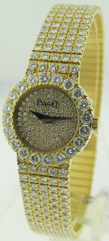 This is a Yellow Gold and Diamond Piaget bracelet watch with a pave diamond dial and mechanical manual-wind movement. The case size is 21mm. The length of the watch is 175mm. There are more than 12 carats of diamonds on the bracelet and case!