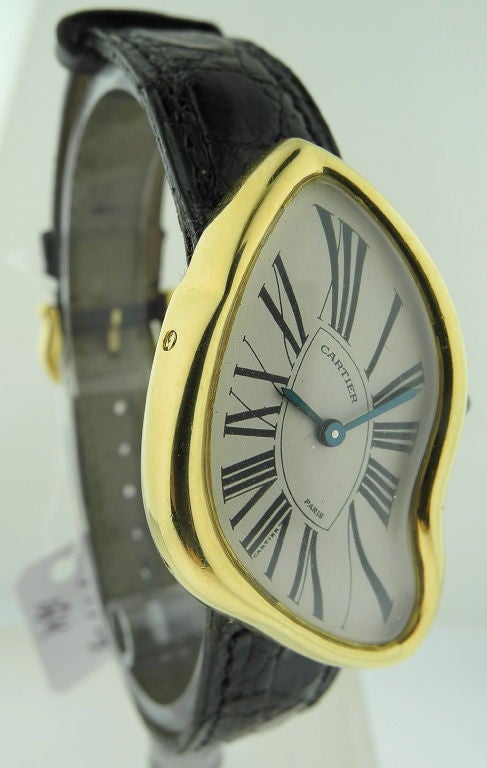 This is Cartier 18k yellow gold Crash with 18K yellow gold asymmetrical case. The watch is a limited edition number 218 of 300, circa 1991. This watch is in good condition and has the certificate and guarantee card.