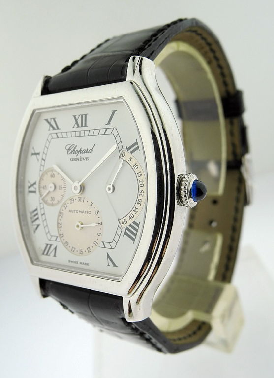 This is a Chopard, platinum tonneau -form automatic wristwatch with date and power reserve indication. Manufactured in circa 2000. Movement: Cal.9644 automatic nickel lever movement, 21 jewels, mono-metallic balance. Dial: white dial, Roman