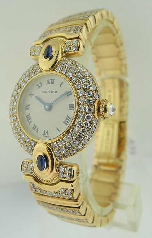 This is a Cartier lady's fine and elegant 18K gold, sapphire and diamond-set wristwatch with bracelet. Signed Cartier, Quartz, case no. 80'579'130'028. Manufactured circa 1995. Quartz movement, 4 jewels, cream dial, Roman numerals, blued steel