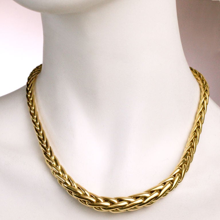 Klassisches geflochtenes Collier CAPLAIN aus 18 Karat Gold, signiert von der berühmten Pariser Goldschmiede CAPLAIN SAINT ANDRE. Die charakteristische Cabachon-Schließe mit blauem Saphir ist das Markenzeichen dieses renommierten Hauses (es beliefert