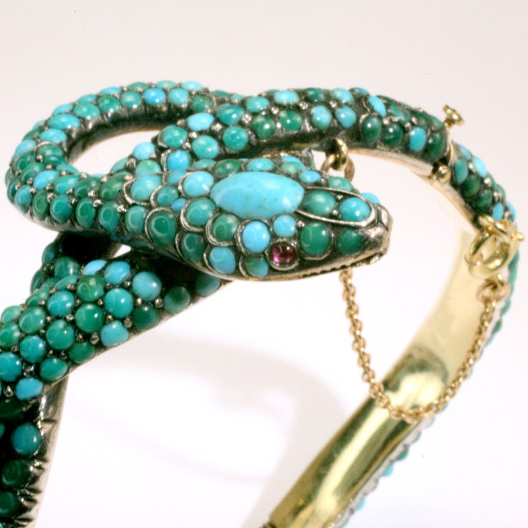 Elegant Victorian snake bangle bracelet with cabochon turquoise beads.  Designed as a coiled snake with large cabochon turquoise crowning the head.  Cabochon ruby eyes.<br />
Marked with French hallmark of an owl.