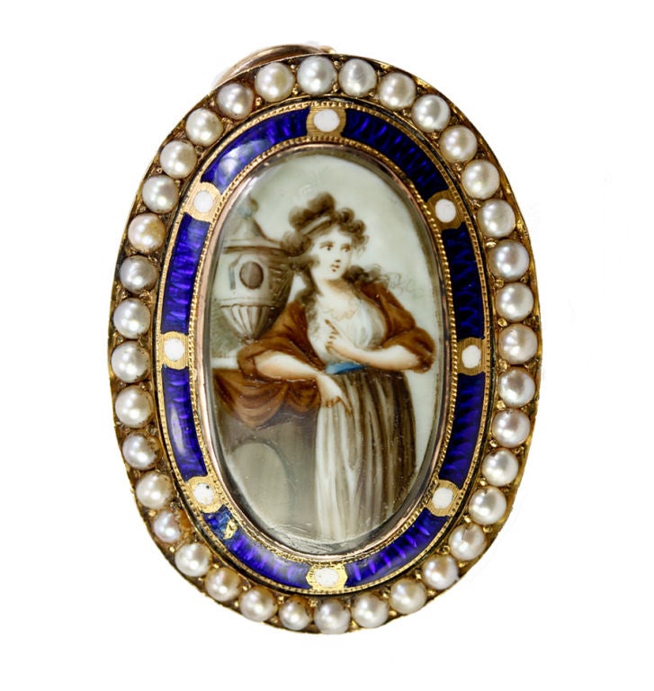 A superb pendant/brooch combination, c.1760-1810, of English origin and style, this mourning jewelry item is opulently framed in a collar of natural seed pearls set with prongs into the 12k yellow gold mount. The inner mat is kiln-fired enamel