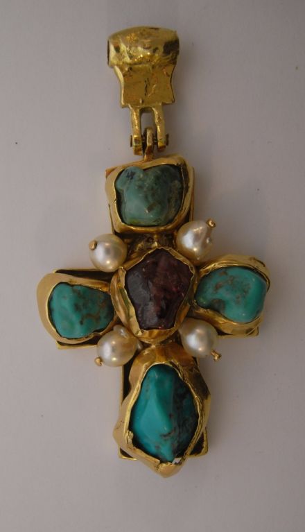 An astonishing cross in 18kt gold set with rough turquoise and a tourmaline, embellished with four cultured pearls.  The rough stones and pressed gold give this cross a Medieval feel.  The verso side of the pendant has an incised image of a Byantine